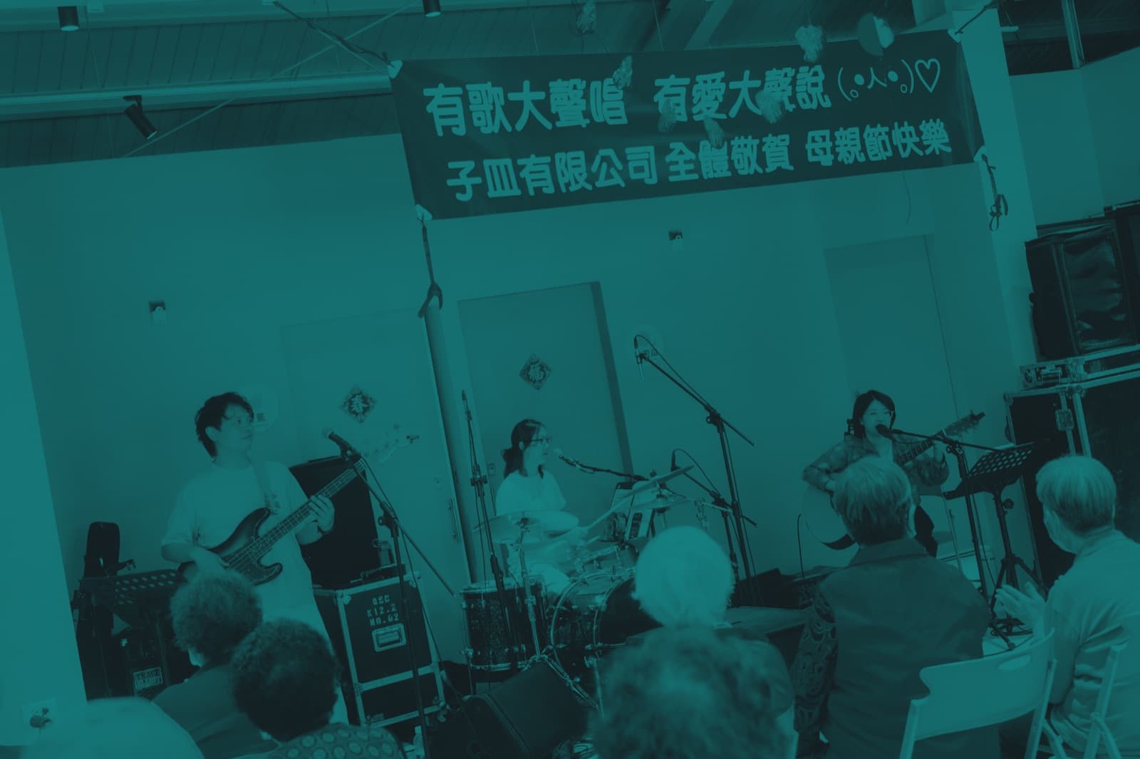 A band performing to a seated audience at a community hall